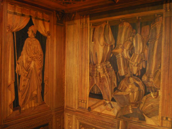 Northeast corner of Urbino intarsia, with Federico in humanist's robes and his armor at right.